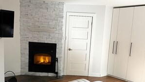 Un dormitorio moderno con chimenea, una cama y un armario.