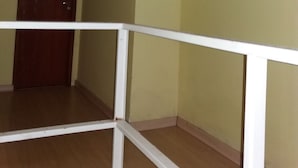 Une pièce avec une porte en bois, une rambarde blanche et un tableau représentant un phare accroché au mur.