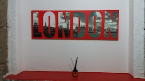 Un mur orné d’un grand tableau encadré de rouge et de noir, représentant Londres.