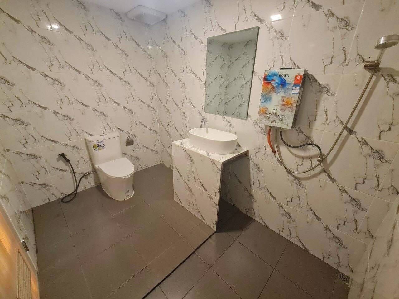 A bathroom with a toilet, sink, and shower.