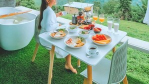 Mesa de comedor al aire libre con vistas a colinas verdes.