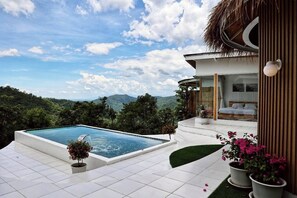 Una casa moderna con piscina, una camera da letto con un letto e una finestra, e vista sulle montagne.