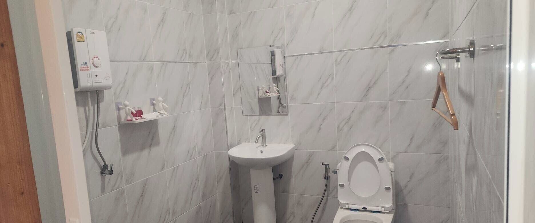 A bathroom with a toilet, sink, and shower.