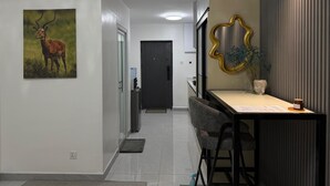 A modern kitchen with a dining area, featuring a kitchen island, chairs, and a decorative mirror.