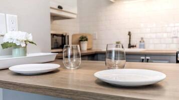 Un comptoir de cuisine avec trois assiettes blanches et deux verres transparents.