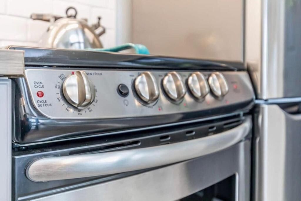 Una cocina con estufa, horno y hervidor.