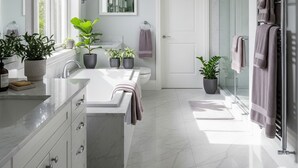 Une salle de bain moderne avec un grand miroir, deux lavabos, une douche et des plantes en pot.