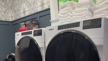Two front-loading Whirlpool washing machines in a laundry room with a window view.