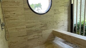 A bathroom with a circular skylight, a shower area, and a view of greenery outside. - Coastal Luxury Getaway for Yoga, Golf & Family Fun (Humacao)