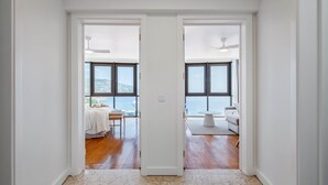 A hallway leading to two rooms with large windows, wooden floors, and a view of the outdoors. - Infinity View by Madeira Sun Travel (Funchal)