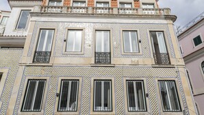 A building with multiple windows, a tiled facade, and balconies.