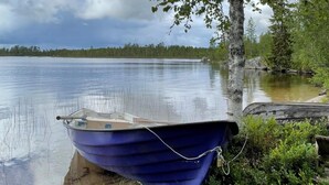 A small blue boat tied to a dock by a tree.
