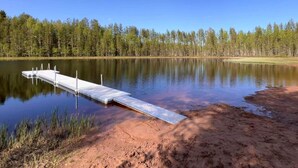 A calm lake with a wooden dock extending into the water.