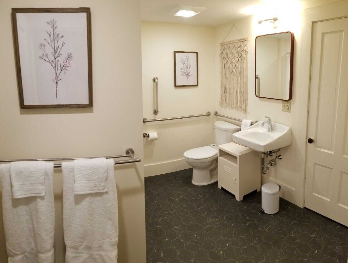 A bathroom with a toilet, sink, and towel rack.