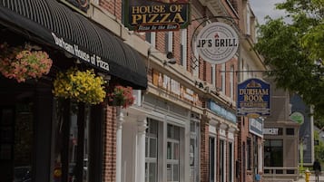 A street view with various shops including House of Pizza, Jp's Grill, Durham Book Exchange, and Juicery.