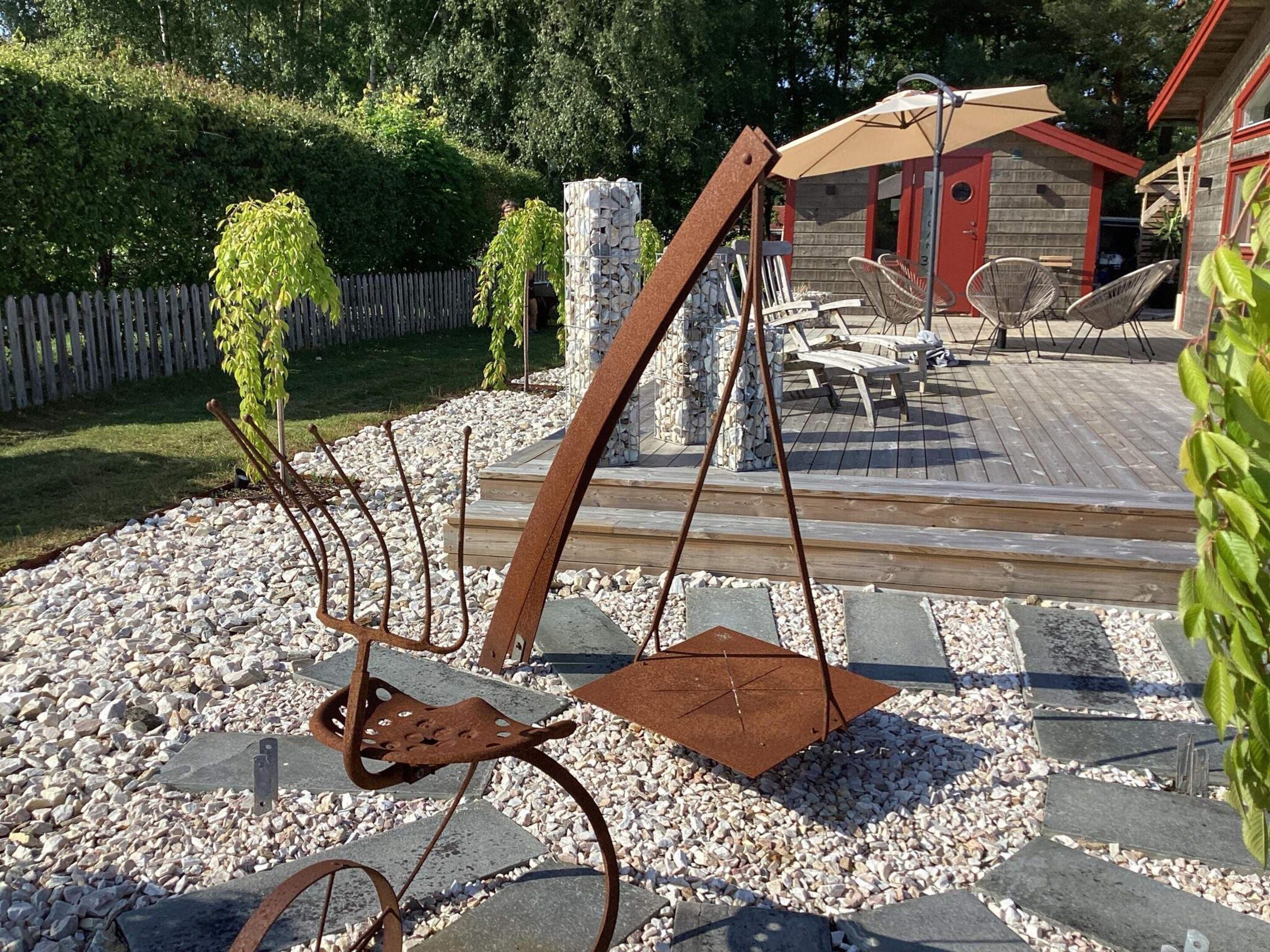 Eine Terrasse mit Schaukel, Steintreppe und Sitzgelegenheiten im Freien.