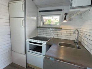A compact kitchen with a built-in oven, a sink, and a window above the countertop. - 4 Star Holiday Home in Skummeslovsstrand (Skummesloevsstrand)