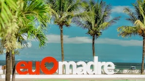 Un cartel con el texto 'eu madre' y palmeras al fondo.