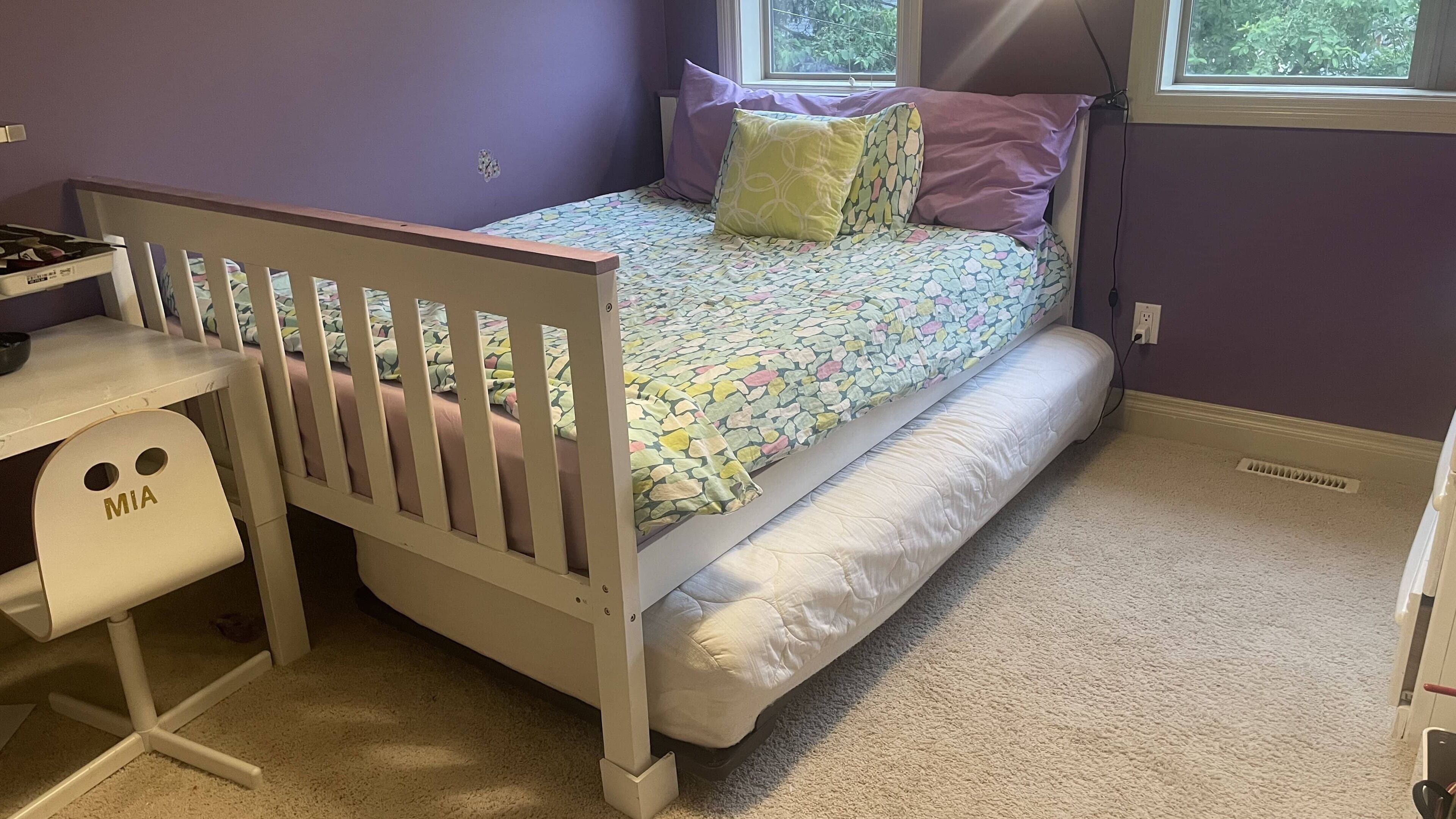 Ein Kinderzimmer mit Bett, Schreibtisch und Stuhl.