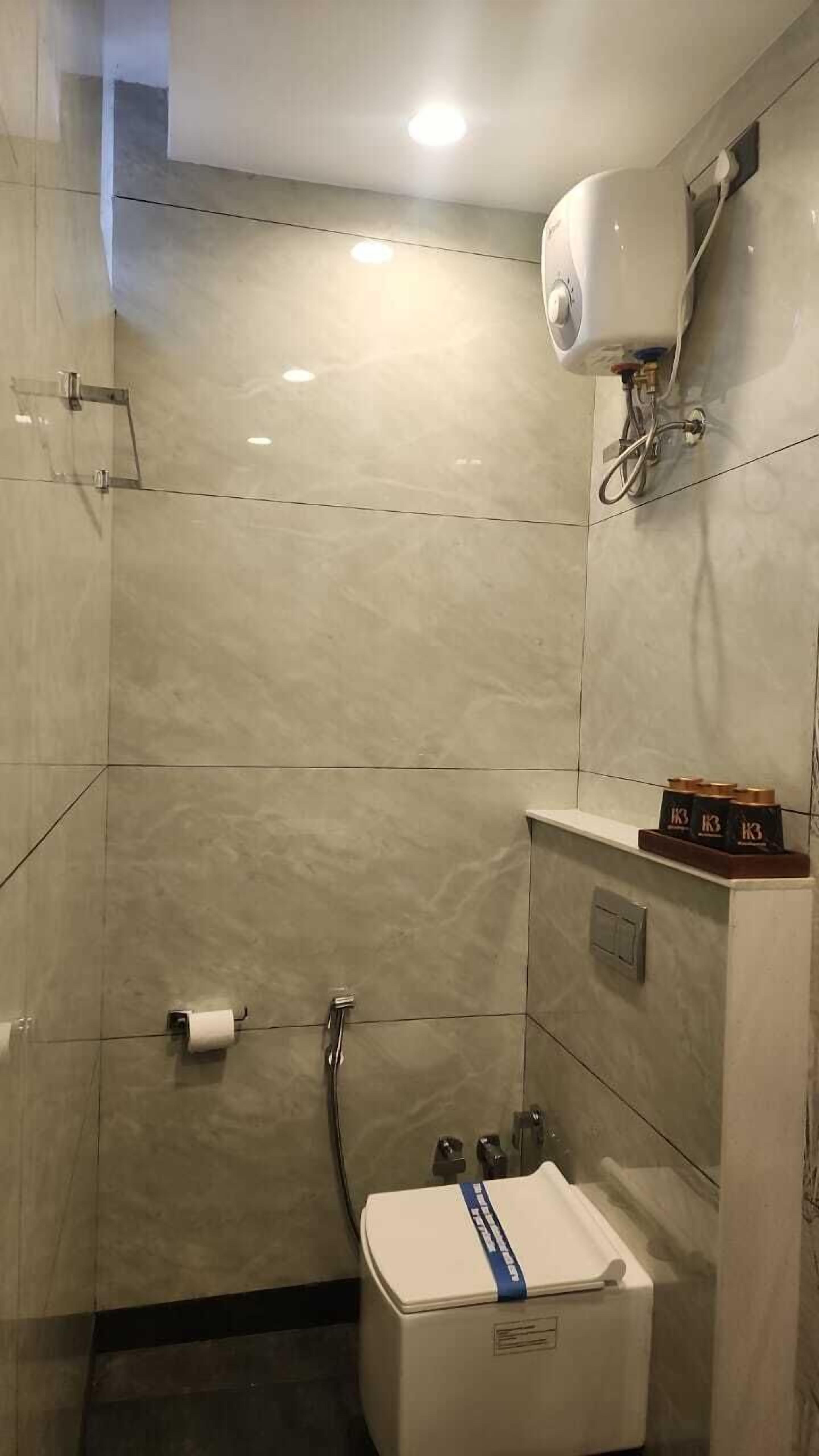 Een badkamer met toilet, hygiëneslot en handdroger.