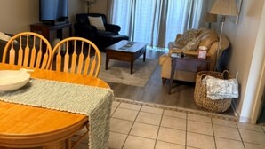 Una sala de estar con comedor, televisor y ventilador de techo.
