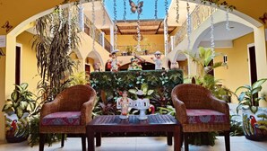Un cortile con mobili in vimini, un tavolo e un arco decorativo.