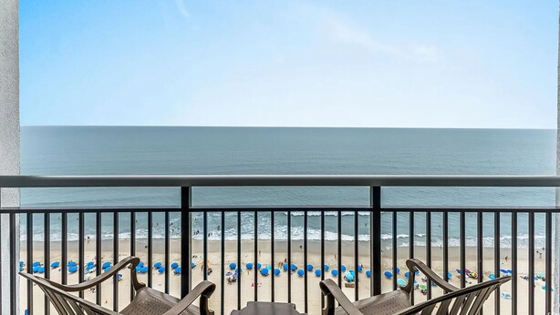 A balcony with a view of a beach and ocean.