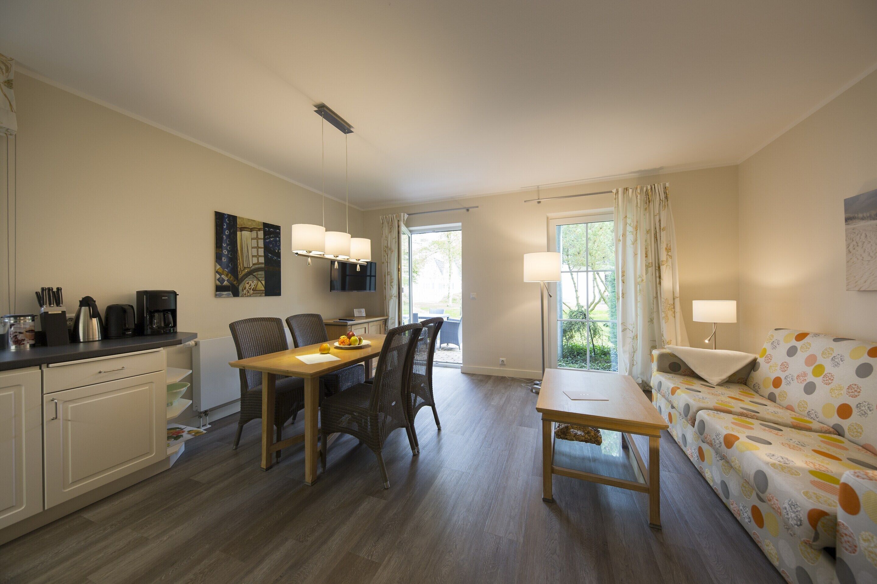 A compact living space with a dining area, kitchen, and a sofa.