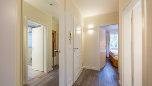 A hallway with wooden flooring, white walls, and doors leading to different rooms. - Ferienwohnung fur Zwei Personen, Dierhagen (Ostseebad Dierhagen)