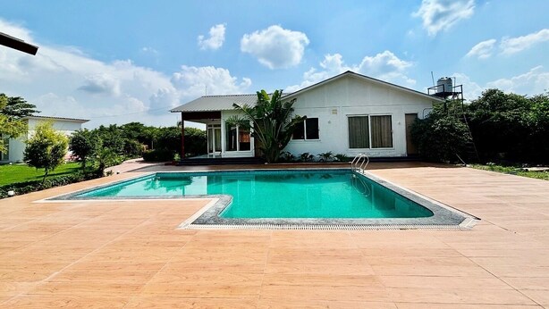 Une maison moderne dotée d’une piscine et d’un patio couvert.