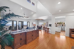 Amplia sala de estar con una isla grande de madera, comedor y cocina con vista.