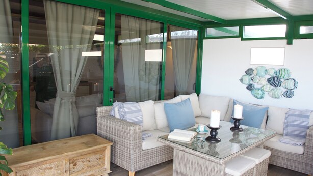 A furnished living area with a sofa, a glass-top coffee table, and a wooden bench.