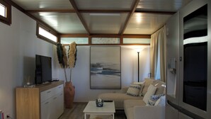 A compact living space with a kitchenette, a sofa, a coffee table, and a TV.
