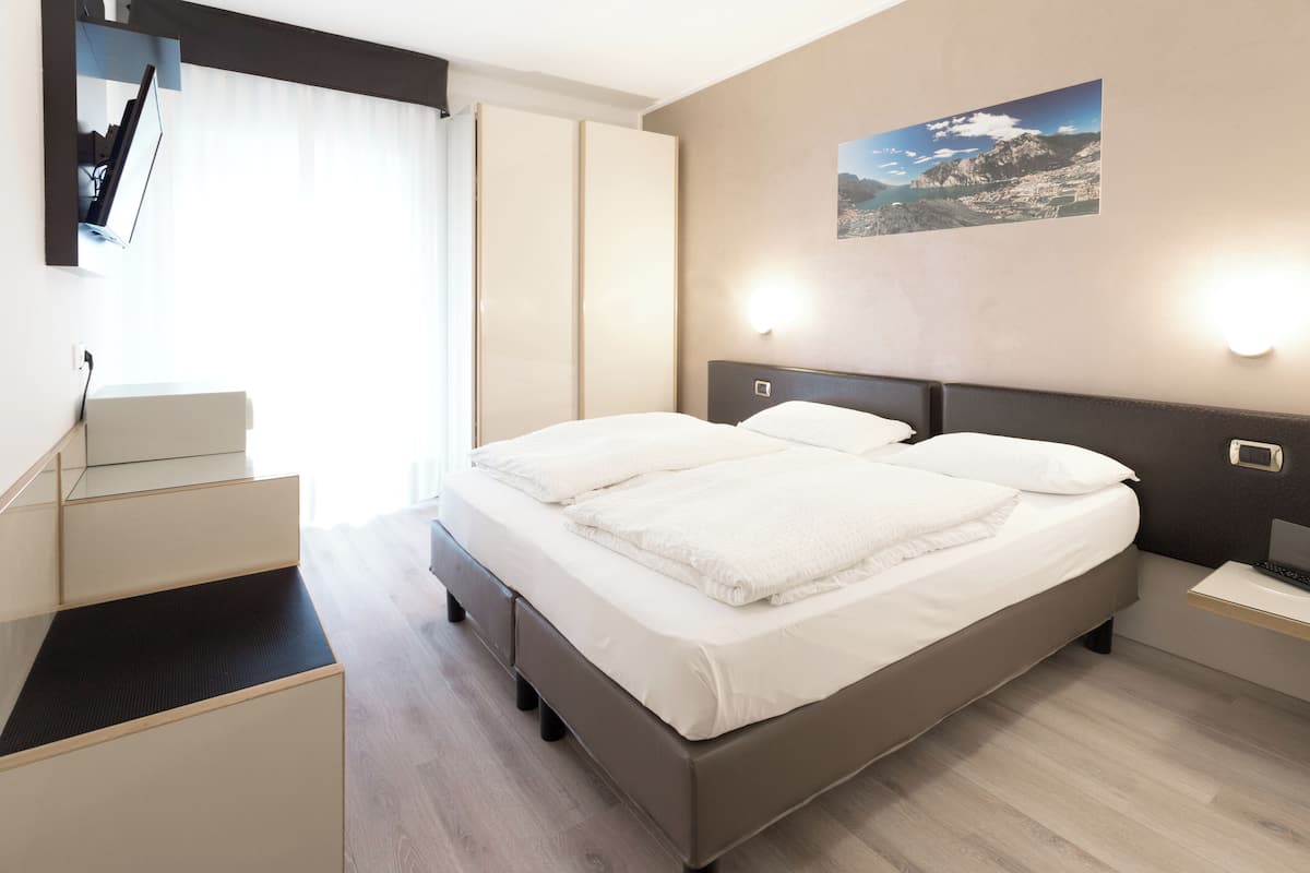 Une chambre d’hôtel moderne équipée d’un grand lit, d’un bureau et d’un téléviseur à écran plat.