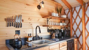 A wooden interior with a kitchen area featuring a sink, kettle, and knife set. - Horizon Hideout | Hot Tub, Mountain Views, Nature Escape (Reynoldsville)
