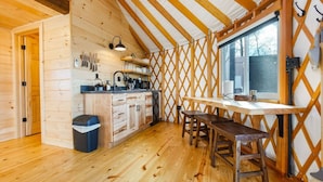 Een kleine keuken met houten kastjes, een aanrecht en een raam.