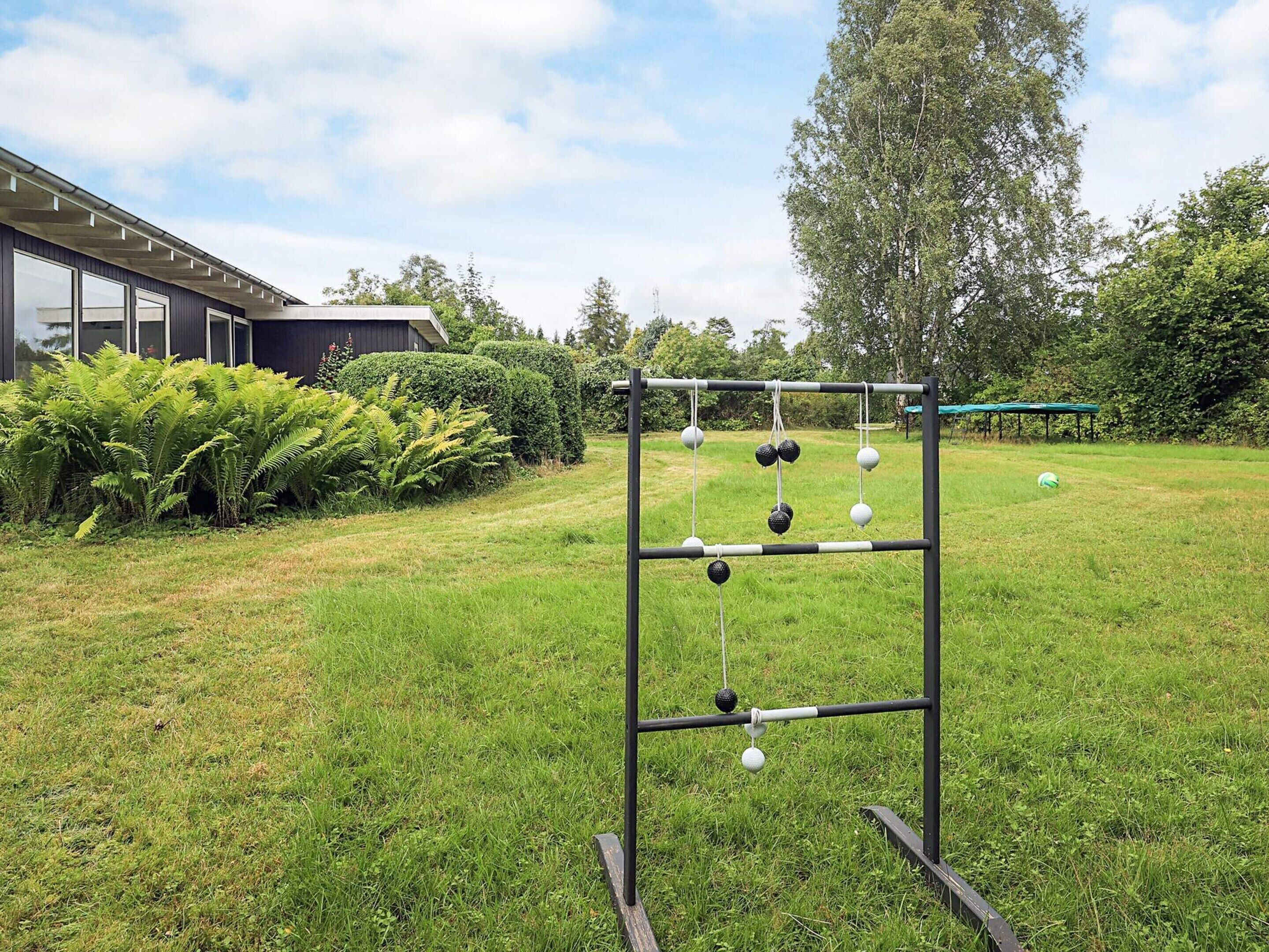 A metal swing set in a grassy yard with a building in the background.