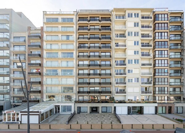 A multi-story residential building with balconies, a central courtyard, and a commercial establishment named "JERRY'S" at the ground level.