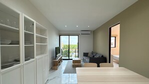 A modern living room with a dining area, a sofa, and a TV. - Modern apart in Cancun, well located, amenities. 2 bedrooms and 2 full bathrooms (Cancún)