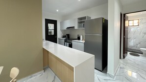 A modern kitchen with white cabinets, a stainless steel refrigerator, and a marble floor. - Modern apart in Cancun, well located, amenities. 2 bedrooms and 2 full bathrooms (Cancún)