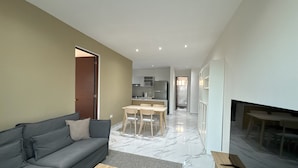 A modern living room with a grey sofa, wooden coffee table, and a fireplace. - Modern apart in Cancun, well located, amenities. 2 bedrooms and 2 full bathrooms (Cancún)