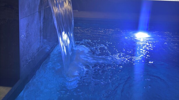 A nighttime indoor pool with a waterfall feature and blue lighting. - Villa with private pool (Orihuela Costa)