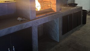 An outdoor kitchen with a built-in fire feature, a sink, and a countertop. - Villa with private pool (Orihuela Costa)