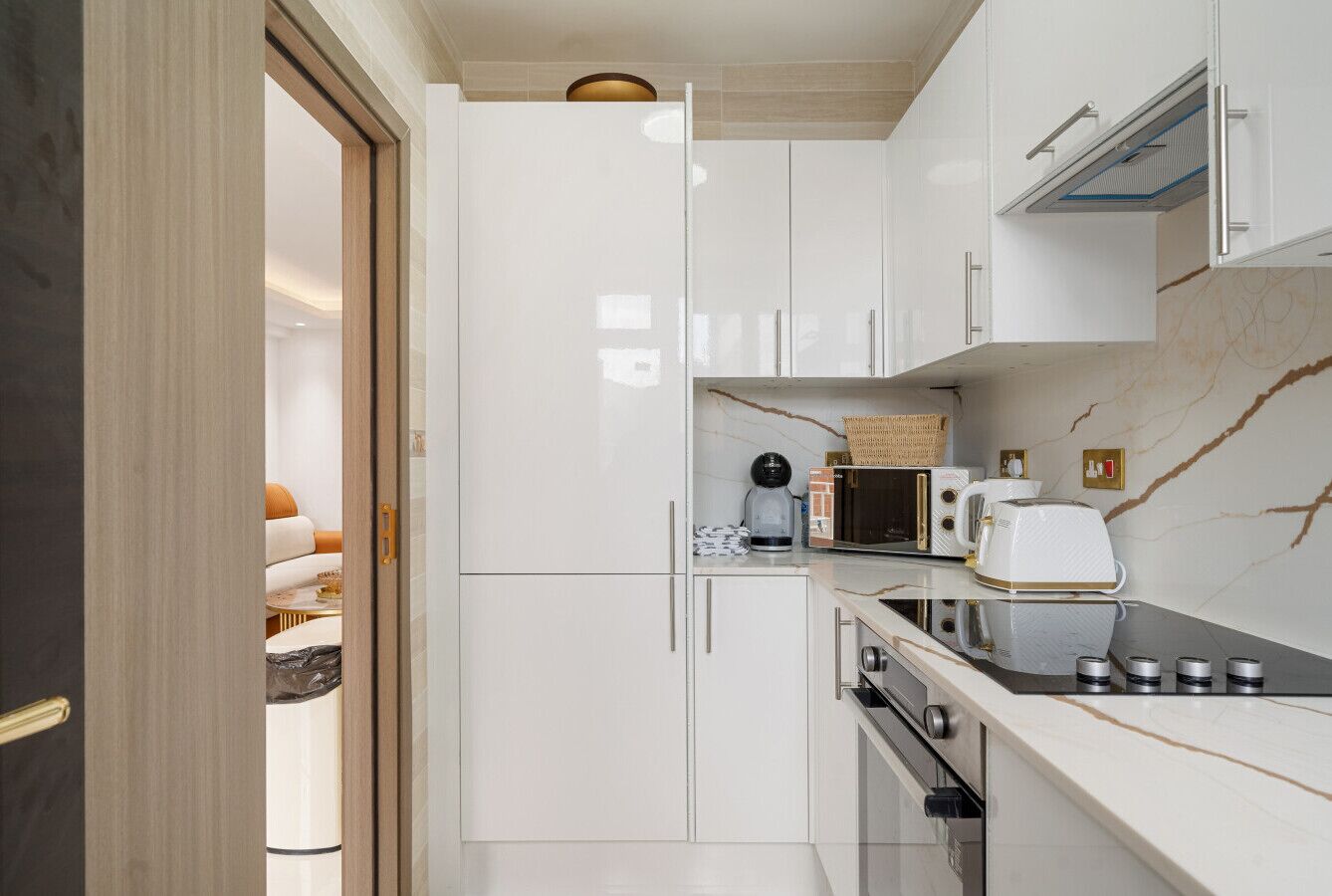 A compact kitchen with white cabinets, a microwave, a toaster, and a stove.