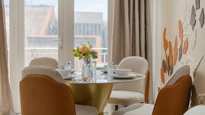 A dining area with a round table, four chairs, and a vase with flowers. - Luxe Mayfair Two Bedroom with Hotel Finish H5 (London)