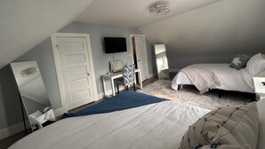 A bedroom with two beds, a desk, a chair, a TV, and a mirror. - 3BR, 4-Bed Home in Port Clinton (Port Clinton)