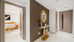 A modern hotel room with a large mirror, a console table, and a sofa.