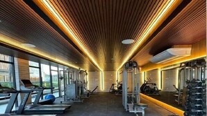 Ein Fitnessstudio mit Laufbändern, Kraftgeräten und Kurzhanteln.