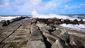 A stone pier extending into the sea with waves crashing against it. - 5 Person Holiday Home in Snedsted (Snedsted)