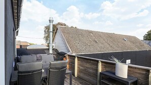 A rooftop deck with outdoor furniture, a chimney, and a wooden fence. - 5 Person Holiday Home in Snedsted (Snedsted)